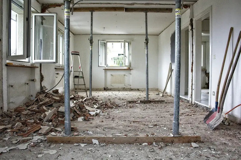 Vivienda en obra con puntales, escombro y paredes sin terminar